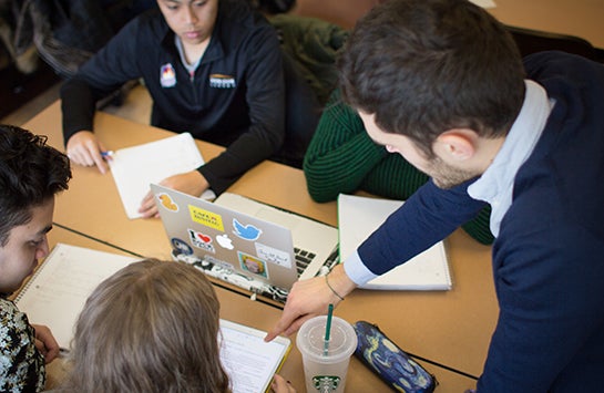 a male French instructor works with a diverse, mixed group of students